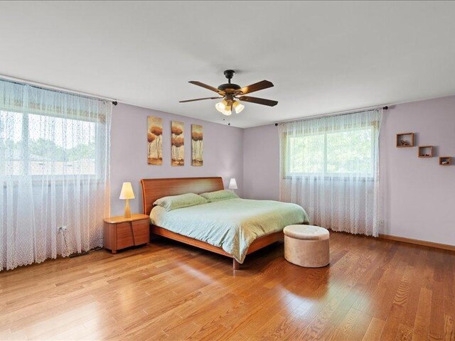 14542 S Mustang Dr, Homer Glen, IL 60491 - bedroom with light wood-style flooring, ceiling fan, multiple closets, and ensuite bath