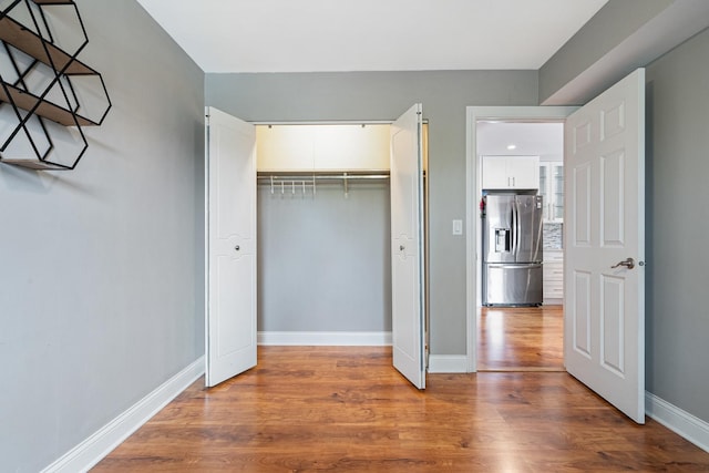810 N River Rd Unit 3A, Mount Prospect, IL 60056 - unfurnished bedroom featuring stainless steel fridge, wood finished floors, baseboards, and a closet