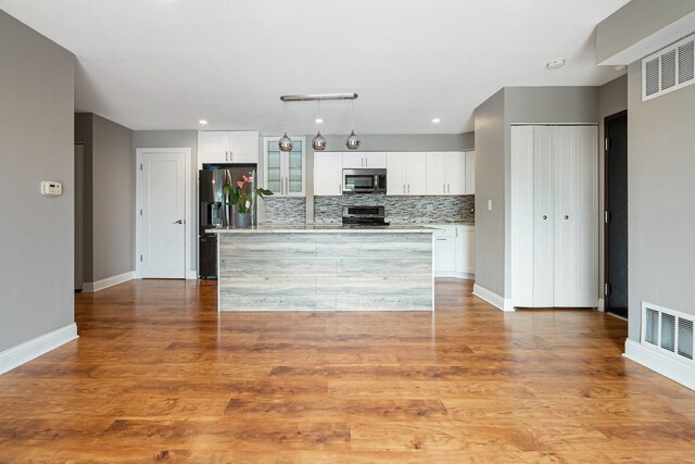 810 N River Rd Unit 3A, Mount Prospect, IL 60056 - kitchen featuring appliances with stainless steel finishes, light countertops, decorative backsplash, and white cabinetry