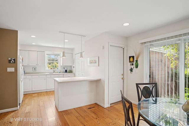 30 W Wimbolton Dr Unit 30, Mount Prospect, IL 60056 - kitchen with white cabinets, white fridge with ice dispenser, light wood-style floors, light countertops, and a peninsula