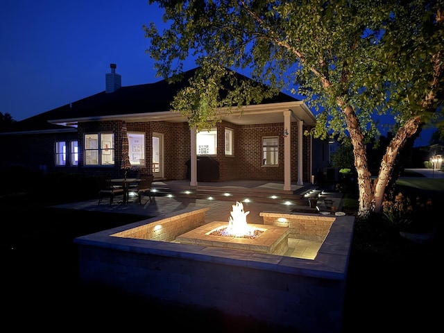 3880 W Nettle Creek Dr, Morris, IL 60450 - patio at night with an outdoor fire pit and a patio area