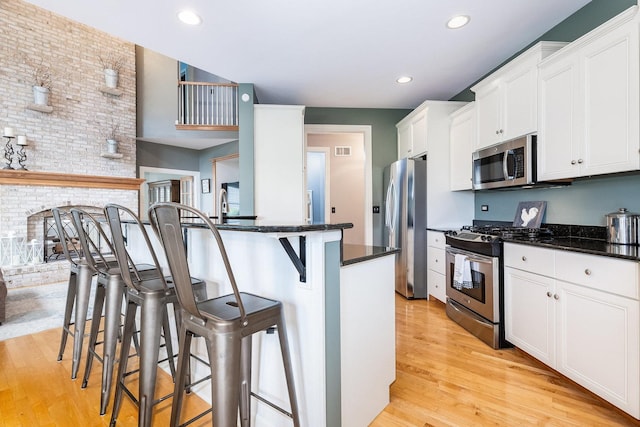 769 Brighton Dr, Sugar Grove, IL 60554 - kitchen with stainless steel appliances, light wood-type flooring, a breakfast bar, white cabinetry, and recessed lighting