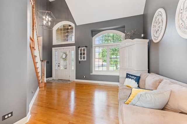 769 Brighton Dr, Sugar Grove, IL 60554 - foyer entrance featuring stairs, a chandelier, light wood-style flooring, baseboards, and high vaulted ceiling