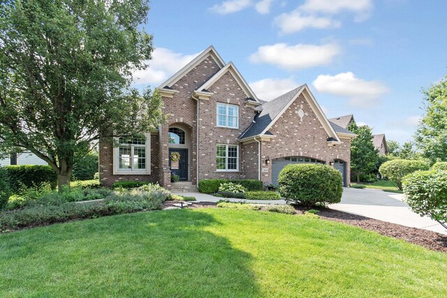 769 Brighton Dr, Sugar Grove, IL 60554 - traditional home featuring concrete driveway, brick siding, a front lawn, and an attached garage