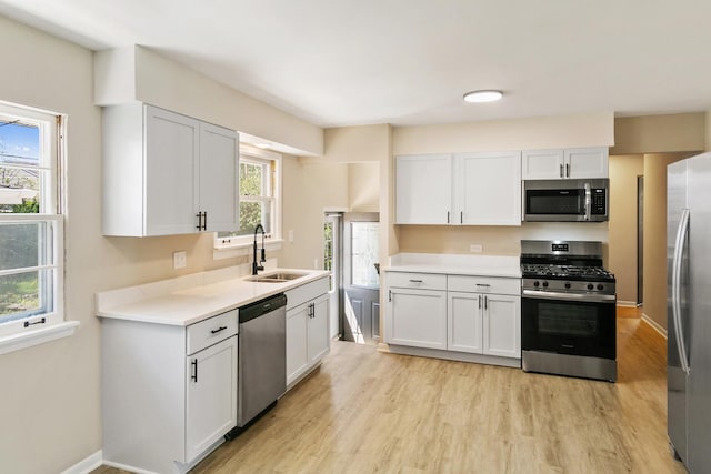 482 Fitch Rd, Chicago Heights, IL 60411 - kitchen with stainless steel appliances, a sink, light wood-style floors, light countertops, and white cabinetry