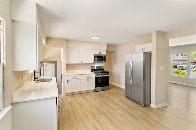 482 Fitch Rd, Chicago Heights, IL 60411 - kitchen with stainless steel appliances, light wood-type flooring, a sink, light countertops, and white cabinetry