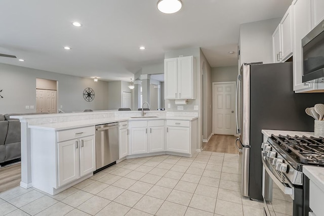 11316 Maplewood Dr, Plainfield, IL 60585 - kitchen featuring stainless steel appliances, a peninsula, open floor plan, light countertops, and white cabinetry