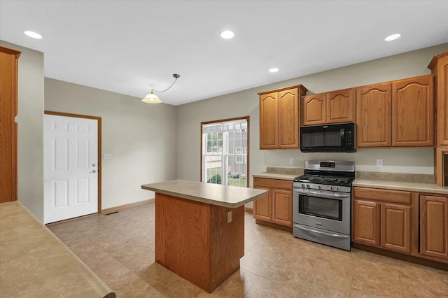 2104A Lucille Ln, Mahomet, IL 61853 - kitchen featuring black microwave, stainless steel gas stove, light countertops, a center island, and brown cabinetry