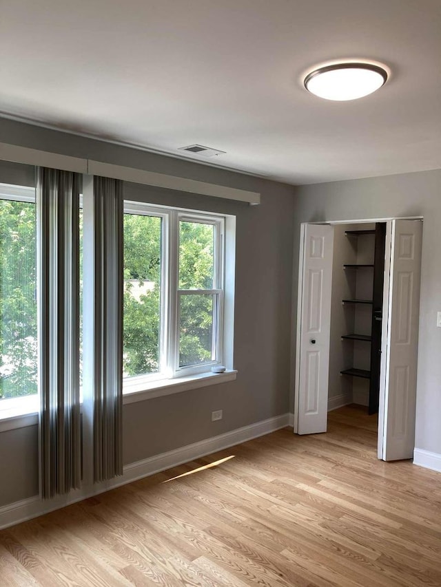 3431 N Kostner Ave, Chicago, IL 60641 - unfurnished bedroom with light wood-style floors, baseboards, and a closet