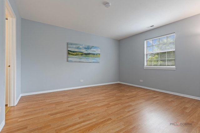 557 E Shag Bark Ln Unit H, Streamwood, IL 60107 - unfurnished room with a smoke detector, light wood-style floors, and baseboards