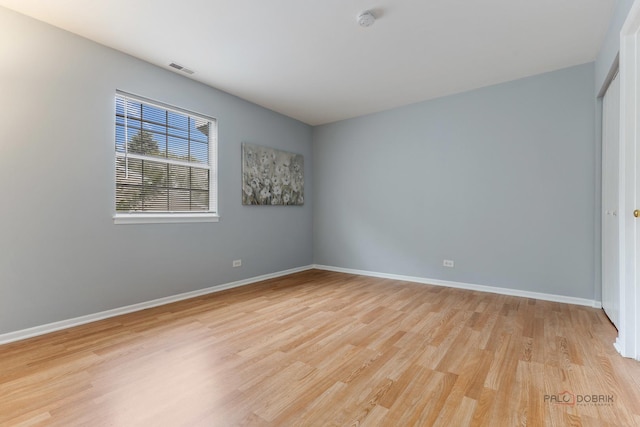 557 E Shag Bark Ln Unit H, Streamwood, IL 60107 - unfurnished room featuring light wood finished floors, baseboards, and a smoke detector