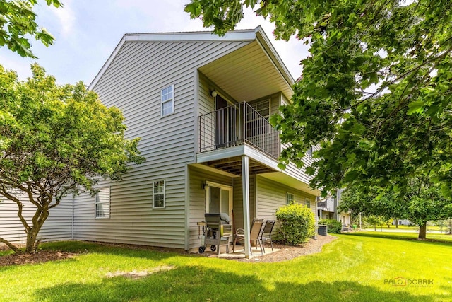 557 E Shag Bark Ln Unit H, Streamwood, IL 60107 - view of front of home featuring a balcony, a front lawn, and a patio