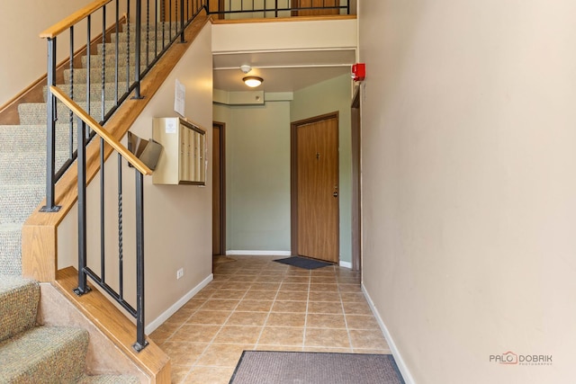 557 E Shag Bark Ln Unit H, Streamwood, IL 60107 - stairs featuring tile patterned floors and baseboards
