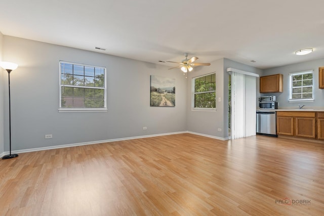 557 E Shag Bark Ln Unit H, Streamwood, IL 60107 - unfurnished living room with light wood-style floors, a sink, a ceiling fan, and baseboards