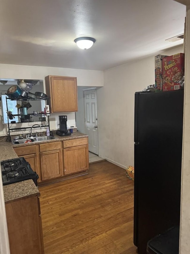 255 Mantua St, Park Forest, IL 60466 - kitchen with freestanding refrigerator, stove, a sink, wood finished floors, and brown cabinets