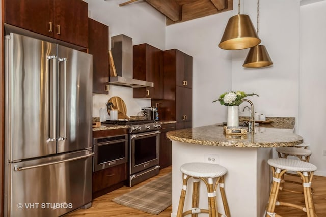 1040 W Adams St Unit 365, Chicago, IL 60607 - kitchen featuring high end appliances, wall chimney range hood, a breakfast bar area, light wood-style flooring, and beam ceiling