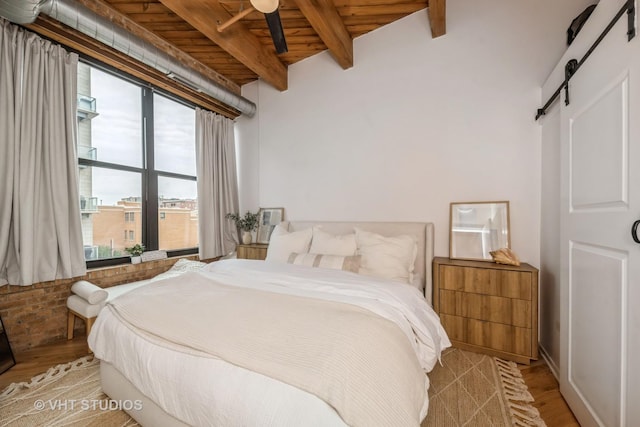 1040 W Adams St Unit 365, Chicago, IL 60607 - bedroom featuring a barn door, light wood-style flooring, and wooden ceiling with exposed beams