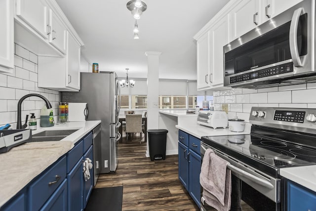 6301 N Sheridan Rd Unit 18E, Chicago, IL 60660 - kitchen with appliances with stainless steel finishes, blue cabinets, a chandelier, white cabinetry, and backsplash