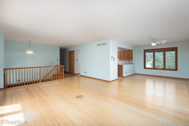 6560 Hillcrest Rd, Downers Grove, IL 60516 - unfurnished living room featuring light wood-style floors, a ceiling fan, and baseboards