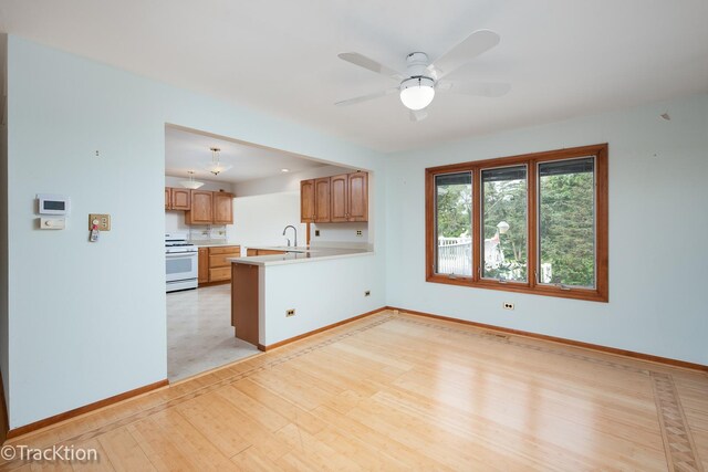 6560 Hillcrest Rd, Downers Grove, IL 60516 - kitchen featuring white range with gas cooktop, light wood finished floors, baseboards, light countertops, and a ceiling fan