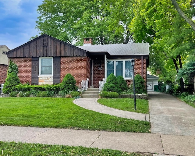 view of front of property with brick siding, a front yard, a chimney, and board and batten siding