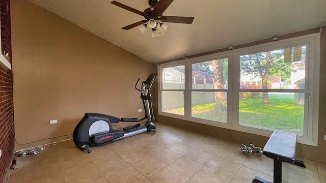workout room featuring healthy amount of natural light, ceiling fan, tile patterned floors, and vaulted ceiling