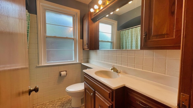 full bath with tile walls, vanity, tile patterned floors, and a shower with shower curtain
