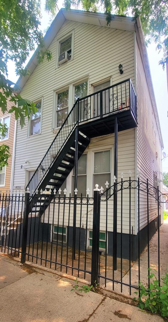 4751 S Hoyne Ave, Chicago, IL 60609 - view of front facade with a balcony, a fenced front yard, stairs, and cooling unit