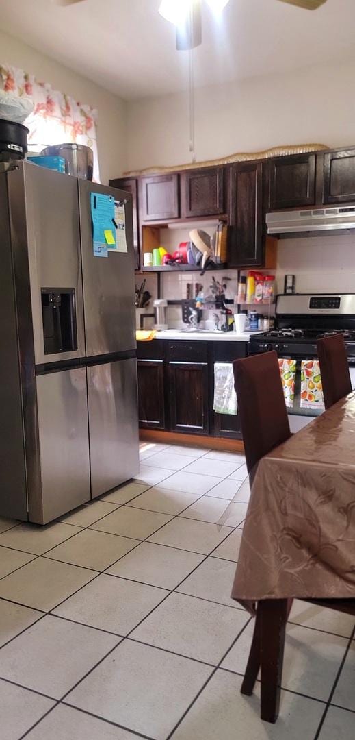 4751 S Hoyne Ave, Chicago, IL 60609 - kitchen with appliances with stainless steel finishes, under cabinet range hood, light tile patterned flooring, and dark brown cabinets
