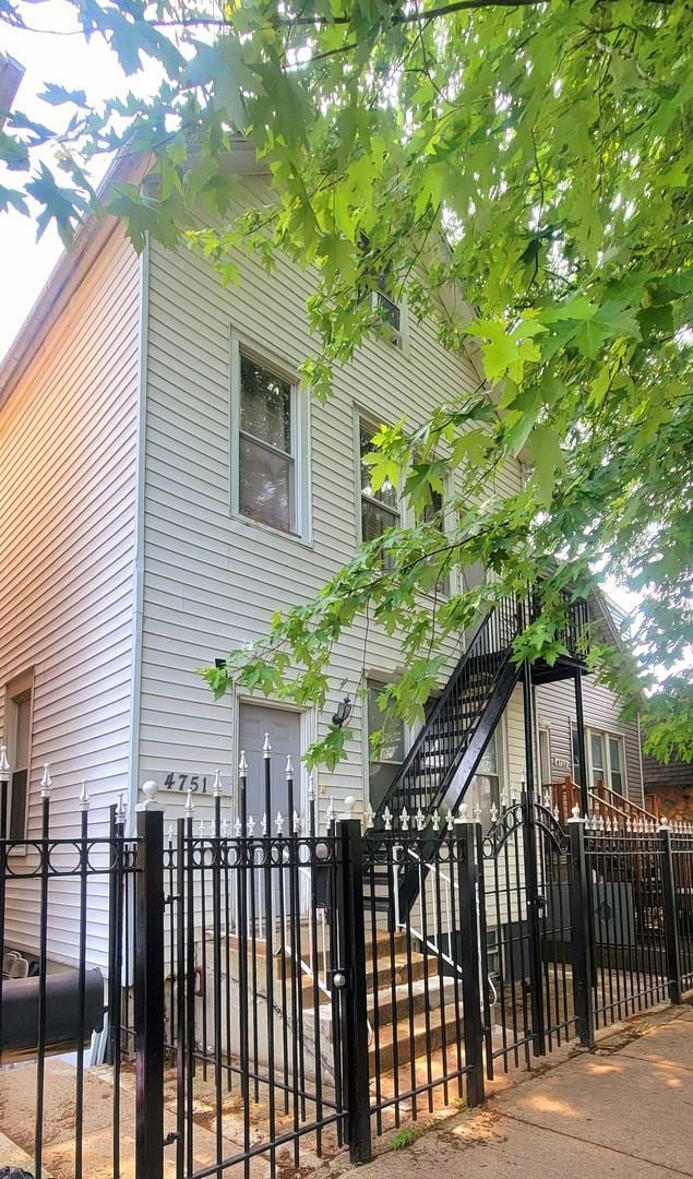 4751 S Hoyne Ave, Chicago, IL 60609 - view of side of home featuring a fenced front yard and stairs