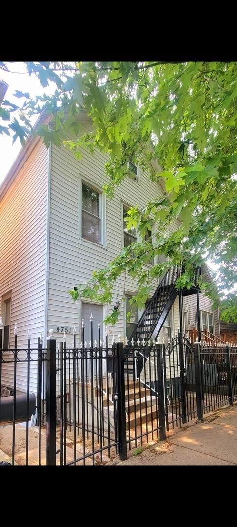 4751 S Hoyne Ave, Chicago, IL 60609 - view of side of home with a fenced front yard and stairway