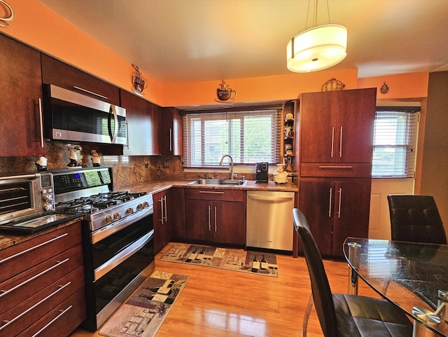 7108 Niles Ave, Niles, IL 60714 - kitchen featuring stainless steel appliances, a sink, light wood-type flooring, pendant lighting, and decorative backsplash