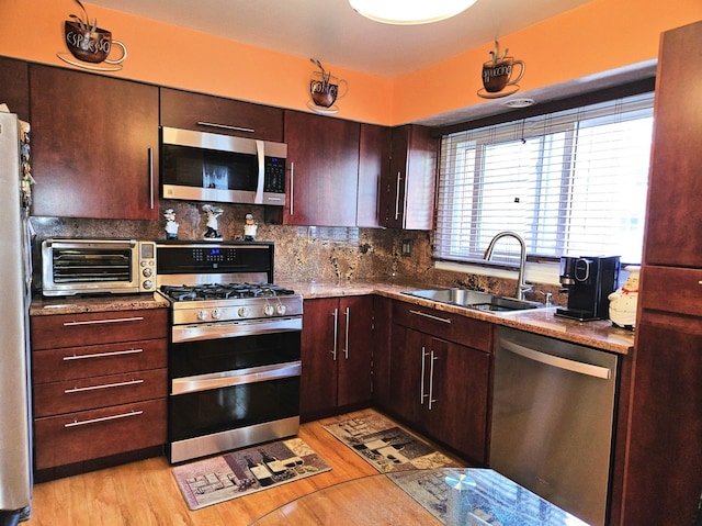 7108 Niles Ave, Niles, IL 60714 - kitchen featuring appliances with stainless steel finishes, a sink, tasteful backsplash, and light wood-style floors
