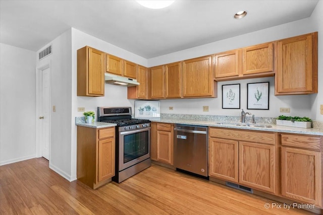 2040 Peach Tree Ln, Algonquin, IL 60102 - kitchen featuring stainless steel appliances, a sink, light wood-type flooring, under cabinet range hood, and baseboards