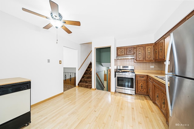 7043 W 73rd St, Nottingham Park, IL 60638 - kitchen featuring appliances with stainless steel finishes, under cabinet range hood, light wood finished floors, ceiling fan, and brown cabinets