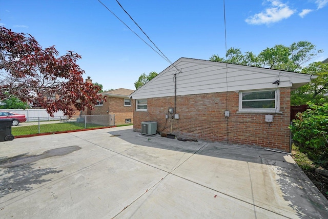 7830 S Kolmar Ave, Chicago, IL 60652 - view of home's exterior featuring brick siding, a patio area, cooling unit, and a chimney