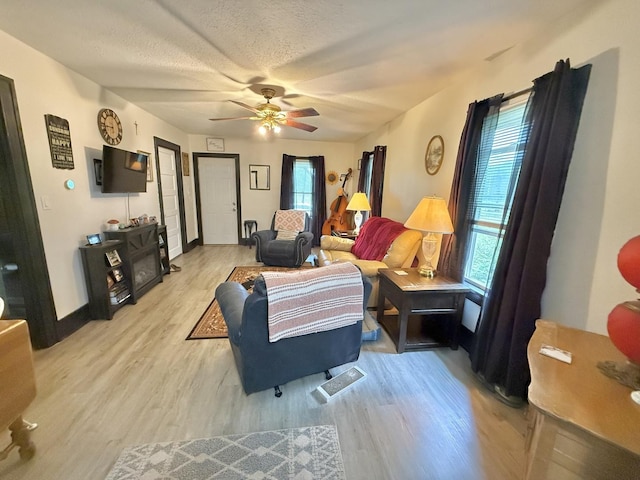 1229 W 6th St, Sterling, IL 61081 - living area with light wood-style flooring, a ceiling fan, a textured ceiling, and baseboards