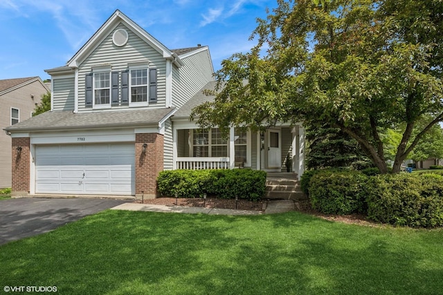 7702 Geneva Dr, Gurnee, IL 60031 - view of front of home with an attached garage, asphalt driveway, a front yard, and a porch