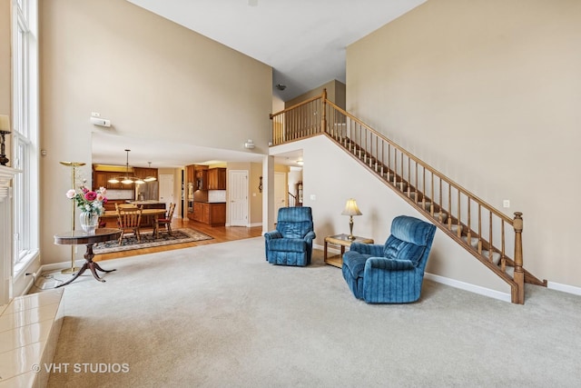 1051 Chadwick Ct, Aurora, IL 60502 - living area with carpet flooring, stairway, a high ceiling, and a chandelier