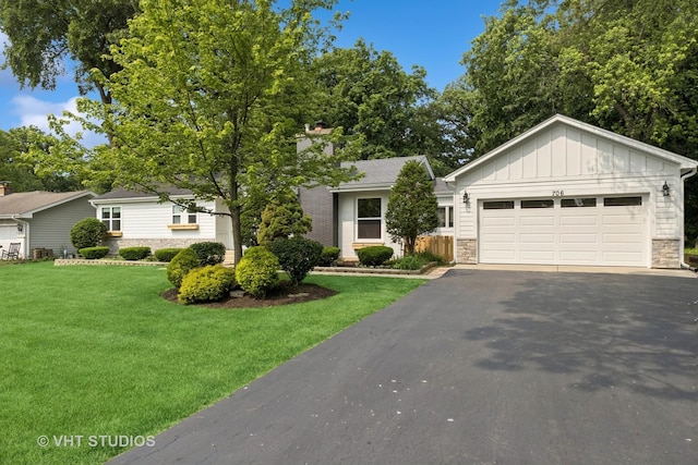 0S706 Madison St, Winfield, IL 60190 - view of front of house featuring stone siding, driveway, a front lawn, board and batten siding, and an attached garage