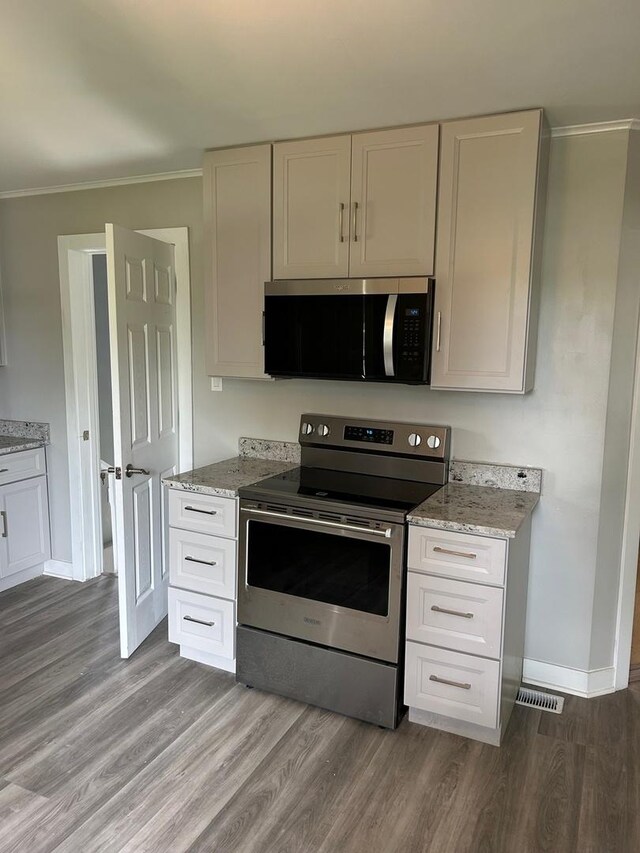 904 Johnson St, Streator, IL 61364 - kitchen featuring stainless steel appliances, ornamental molding, wood finished floors, and light stone countertops