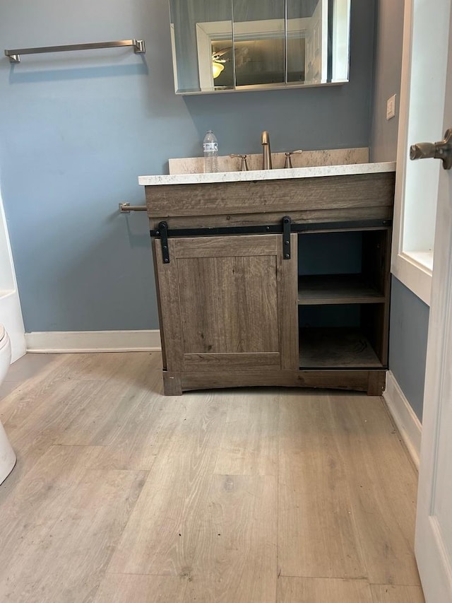904 Johnson St, Streator, IL 61364 - bathroom featuring wood finished floors, vanity, baseboards, and toilet