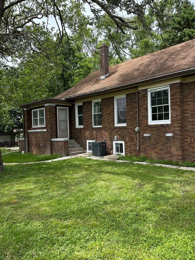904 Johnson St, Streator, IL 61364 - rear view of house with a chimney, central AC, a lawn, and brick siding
