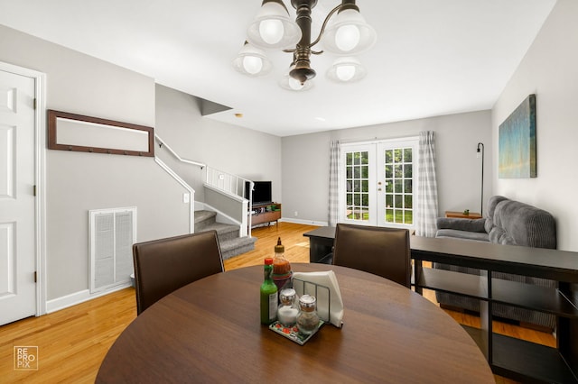 525 W Washington Ave Unit 6, Lake Bluff, IL 60044 - dining area with a chandelier, french doors, stairs, and light wood-style flooring