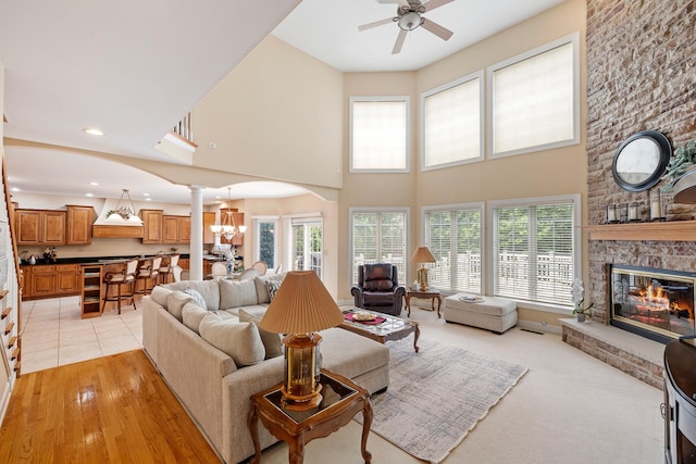 13738 Legend Trail Ln, Orland Park, IL 60462 - living room with ornate columns, a ceiling fan, plenty of natural light, a large fireplace, and a towering ceiling