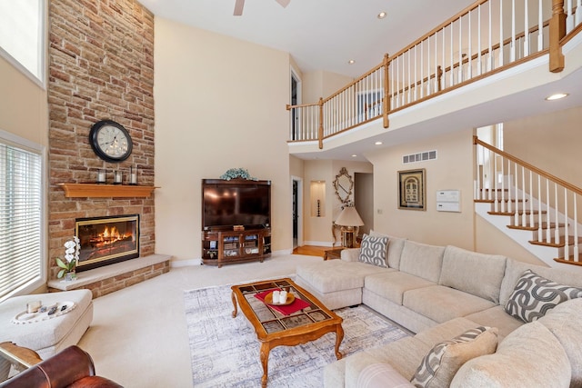 13738 Legend Trail Ln, Orland Park, IL 60462 - carpeted living area featuring a high ceiling, a stone fireplace, a ceiling fan, stairway, and baseboards