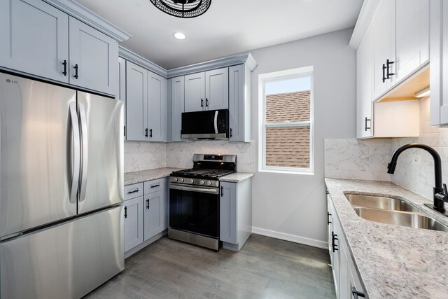 7925 S May St, Chicago, IL 60620 - kitchen with stainless steel appliances, a sink, baseboards, wood finished floors, and tasteful backsplash