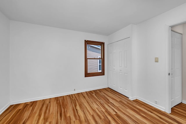 402 Kenyon Ave, Romeoville, IL 60446 - unfurnished bedroom with light wood-type flooring, baseboards, and a closet