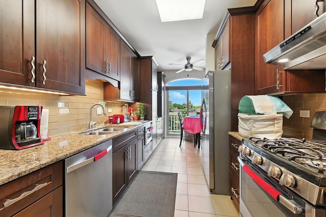 170 Manchester Dr Unit 406, Buffalo Grove, IL 60089 - kitchen featuring appliances with stainless steel finishes, wall chimney range hood, light tile patterned floors, light stone counters, and decorative backsplash
