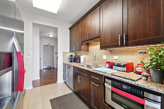 170 Manchester Dr Unit 406, Buffalo Grove, IL 60089 - kitchen with stainless steel appliances, light tile patterned flooring, dark brown cabinets, light stone counters, and backsplash